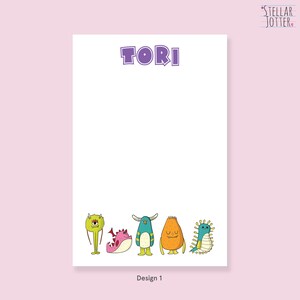 May include: A personalised notepad with the name "TORI" printed in purple at the top. The notepad features a design of five colourful cartoon monsters at the bottom.
