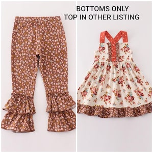 May include: Brown floral print leggings with tiered ruffles at the ankles. A cream-colored dress with a floral pattern, red straps, and a ruffled hem. The text "BOTTOMS ONLY TOP IN OTHER LISTING" is visible.