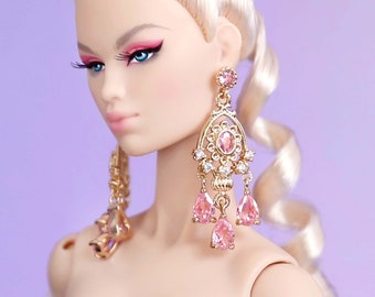 May include: A fashion doll with blonde hair wearing a black strapless top and a white fur stole. The doll is wearing large pink and gold earrings.