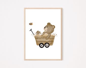 Puede incluir: Ilustración en acuarela de un oso de peluche marrón montado en un vagón de madera lleno de flores blancas. Una abeja amarilla y negra vuela cerca. La obra de arte está enmarcada en un marco de madera clara.