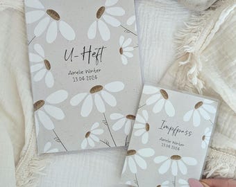 Könnte beinhalten: Zwei weiße und braune, floral gemusterte Hüllen für ein Notizbuch und einen Reisepass. Die Notizbuchhülle trägt den Text "U-Heft" und "Amelie Winter 13.04.2024". Die Reisepasshülle trägt den Text "Impfpass" und "Amelie Winter 13.04.2024".