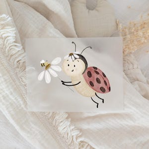 Könnte beinhalten: Aquarell-Illustration eines freundlichen Marienkäfers, der eine Gänseblümchen mit einer Biene hält. Der Marienkäfer hat einen rot-braun gefleckten Panzer, ein Gänseblümchen auf dem Kopf und lächelt. Die Biene ist gelb und braun, und das Gänseblümchen ist weiß.