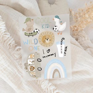 Könnte beinhalten: Eine skurrile Illustration mit einem Vogel auf einem Skateboard, einer Ente mit einem Fußball, einem Löwen, einem Regenbogen und einem Bus mit Tieren. Text enthält "COOL KID", "WILD ONE", "I love mummy" und "I love milk".