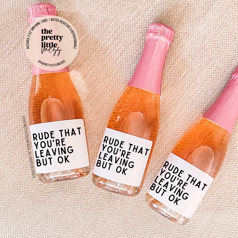 Op de afbeelding: Drie mini flesjes ros&eacute; wijn met witte etiketten waarop staat "Onbeschoft dat je weggaat, maar ok&eacute;".