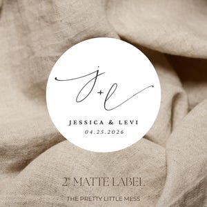 May include: A white, circular matte label with the names "Jessica & Levi" and the date "04.25.2026" in a minimalist font. The label also features the initials "J+L" in elegant cursive script. The label is 2 inches in diameter.