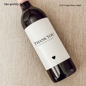May include: A white wine bottle label with black text that reads "Thank You For Everything." A small black heart is at the bottom of the label.