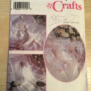 May include: Simplicity Crafts pattern number 8461, one size, for making a white satin ring bearer pillow, a white satin ring bearer pillow with lace trim, and a white satin ring bearer pillow with lace trim and a satin bow. The pattern is titled "ginger kean berk".