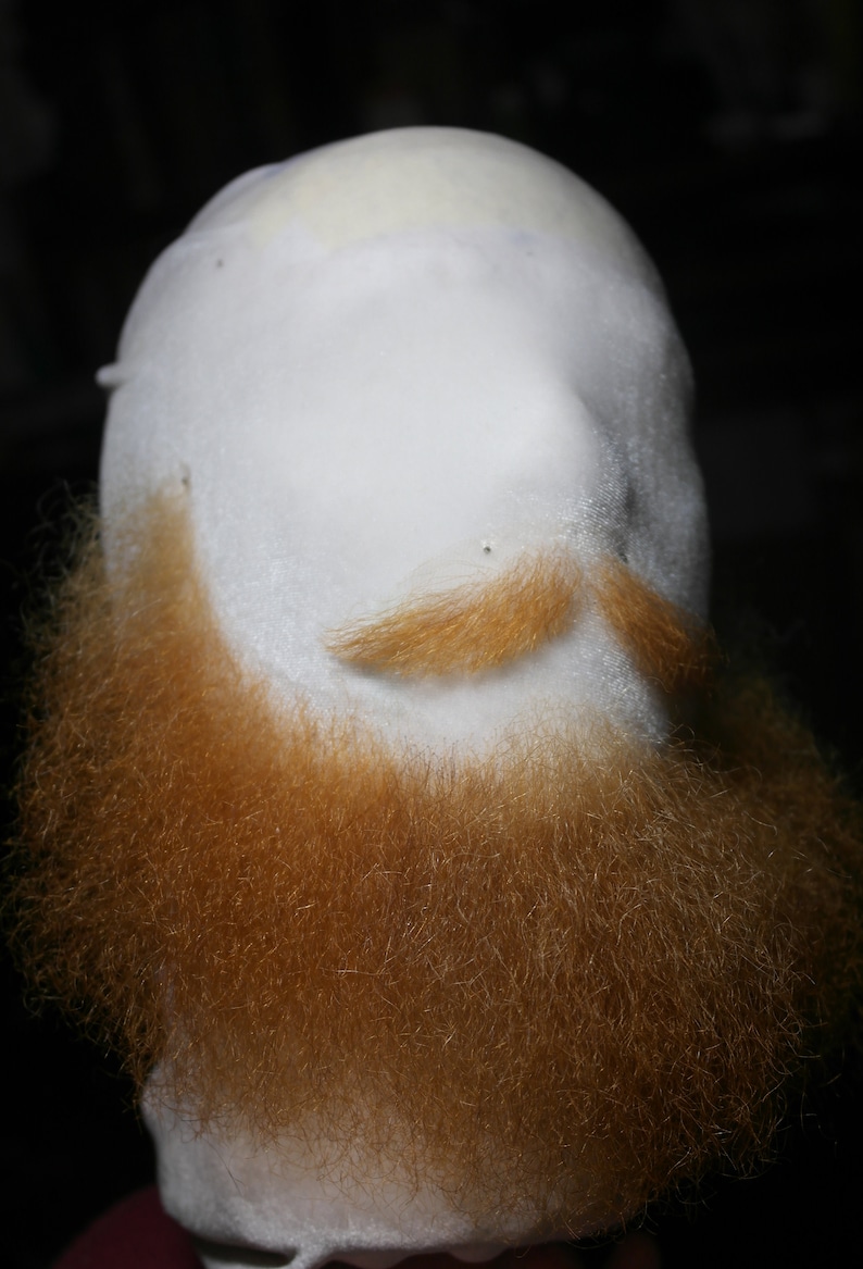 May include: A white mannequin head with a full, reddish-brown beard and a light brown mustache.