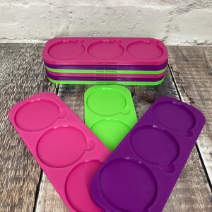 Pu&ograve; includere: Tre stampi in silicone per realizzare oggetti rotondi. Gli stampi sono rosa, verdi e viola. Ogni stampo ha tre cavit&agrave; rotonde.