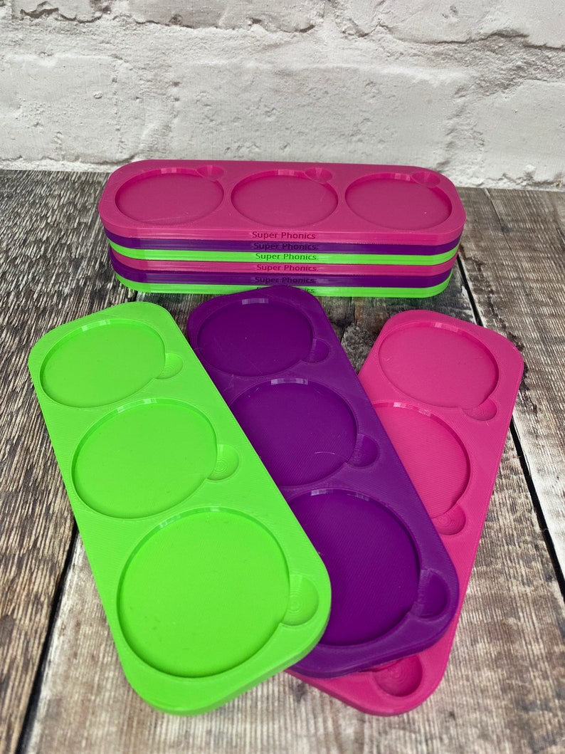 Pu&ograve; includere: Tre stampi in silicone per realizzare oggetti rotondi in resina. Gli stampi sono verdi, viola e rosa. Ogni stampo ha tre cavit&agrave; rotonde. Gli stampi sono impilati uno sopra l'altro.