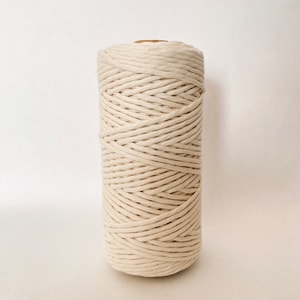 May include: A roll of natural cotton rope, ideal for crafting projects. The rope is tightly wound and has a natural, off-white colour.
