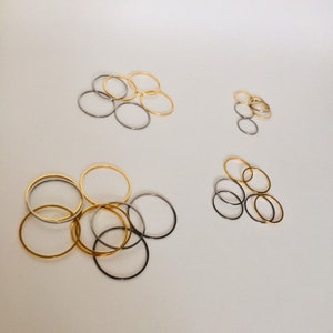 May include: A group of gold and silver rings of different sizes. The rings are arranged in three groups on a white background.
