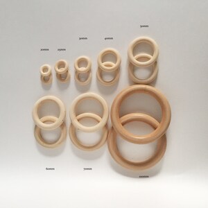 May include: Set of ten wooden rings in various sizes, ranging from 20mm to 100mm in diameter. The rings are all natural wood colour and are arranged in order of size.