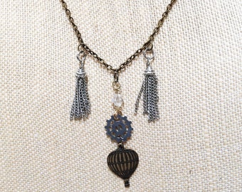 Collar Steampunk con globo aerostático: engranaje de bronce, cristal y borla.