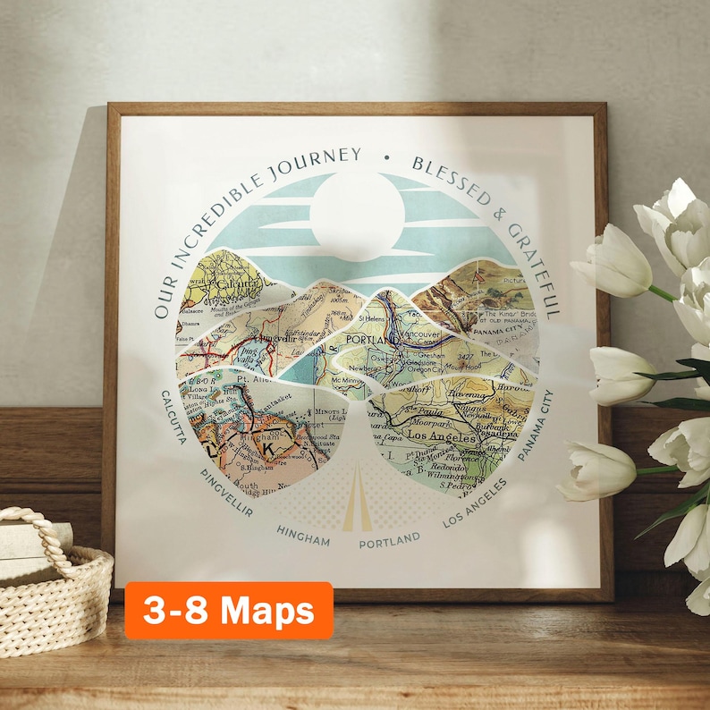 May include: A framed print with a vintage map design. The map is cut into mountain shapes and arranged in a circle. The text "Our Incredible Journey Blessed & Grateful" is written around the circle. The print is on a wooden surface with a bouquet of white flowers.