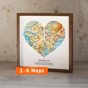 May include: Framed heart-shaped map art with a brown wooden frame. The map is divided into sections, with the word "HAITI" visible. The text "WANDERLUST" and "1-6 Maps" are also displayed. The artwork is designed to inspire travel.