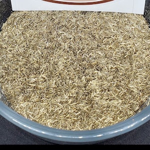 May include: A clear plastic container filled with a large amount of thin, gold-colored metal strands. The container has a white sticker on the side with a brown bull logo and the text "COPPEROX LIMITED".