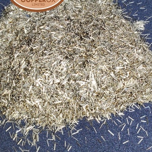May include: A large pile of small, golden, metal pieces, likely brass shavings. The text "COPPER BRASS 60% COPPER 40% ZINC" is visible above the pile. A logo for "COPPEROX LIMITED" is visible in the top left corner of the image.