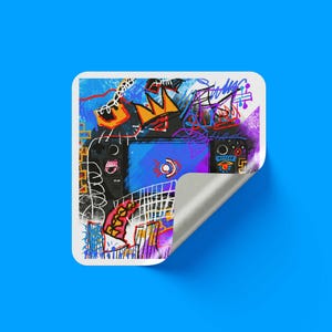 May include: A square sticker with a peeled corner featuring a black handheld gaming console at the center. The design is layered with vibrant, chaotic graffiti-style scribbles, including a yellow crown, blue lines, and red accents on a white background.