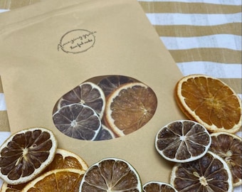 May include: A brown paper bag with a logo that says "Amazing Grace Farm Fresh Made" and a clear window showing dried orange and lemon slices.
