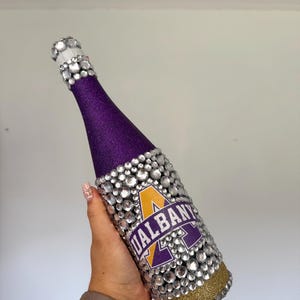 SUNY Albany bottle with purple and gold glitter.