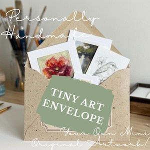 May include: A speckled brown paper envelope containing several small art prints, including a red flower painting and a black and white bird sketch. The envelope features a green overlay with the white text TINY ART ENVELOPE and Personally Handmade.