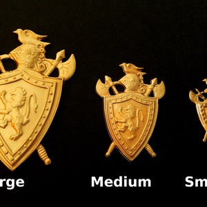 May include: Three gold-colored metal shields with lion crests and swords. The shields are labeled "Large", "Medium", and "Small".