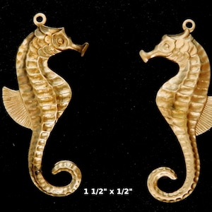 May include: Two gold-tone metal seahorse charms, each measuring 1 1/2 inches in length. The seahorses have a detailed, textured design.