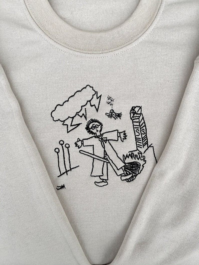May include: A light gray sweatshirt with a black embroidered design of a person holding a broom, a cloud with lightning, and the words "Yah Yah".