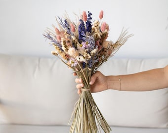 May include: A bouquet of dried flowers in shades of purple, pink, and white. The bouquet includes lavender, grasses, and other dried flowers.