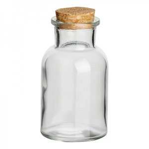 Könnte beinhalten: Eine klare Glasflasche mit einem Korkverschluss. Die Flasche ist zylindrisch geformt und hat einen abgerundeten Boden.