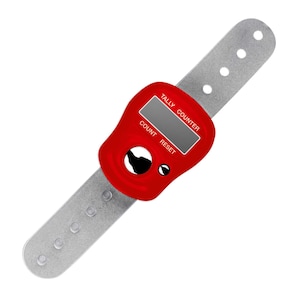 Könnte beinhalten: Ein roter digitaler Zähler mit einem grauen Armband. Der Zähler hat einen kleinen Bildschirm und Tasten mit der Aufschrift "COUNT" und "RESET". Das Armband hat mehrere Löcher zur Größenanpassung. Die Worte "TALLY COUNTER" sind auf dem Zähler aufgedruckt.