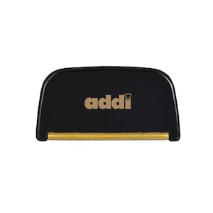 Könnte beinhalten: Ein schwarzer und goldener Stoffrasierer mit dem Wort "addi" und einem Herzlogo auf der Oberseite.