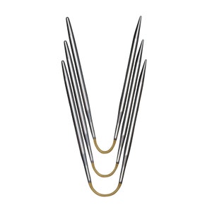 Könnte beinhalten: Ein Satz silberner Rundstricknadeln mit spitzen Spitzen und beigefarbenen, flexiblen Kabeln. Die Nadeln sind in V-Form vor einem weißen Hintergrund angeordnet. Die Nadeln sind für Strickprojekte konzipiert.