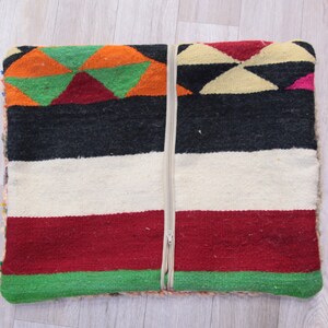 Pu&ograve; includere: Un cuscino tessuto colorato con una chiusura a cerniera. Il cuscino presenta un motivo geometrico in tonalit&agrave; di rosso, verde, arancione, nero e bianco.