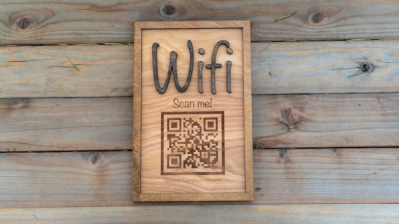 May include: A wooden sign with the word "Wifi" and a QR code that says "Scan me!" The sign is on a wooden background.