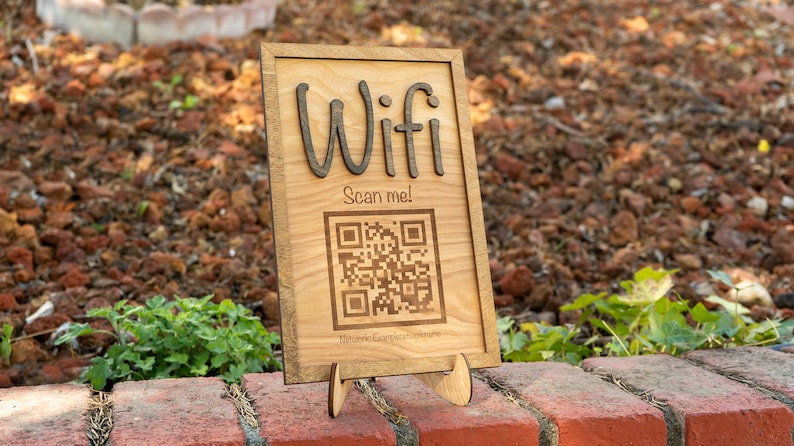May include: A wooden sign with the word "Wifi" and a QR code that says "Scan me!" The sign is on a small wooden stand.