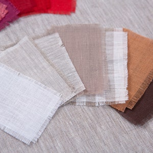 May include: A collection of fabric swatches in various shades of beige, brown, and white. The swatches are arranged in a fan shape and have a frayed edge.