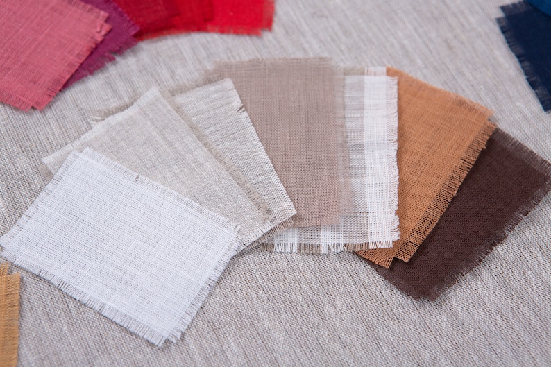 May include: A collection of fabric swatches in various shades of beige, brown, and white. The swatches are arranged in a fan shape and have a frayed edge.