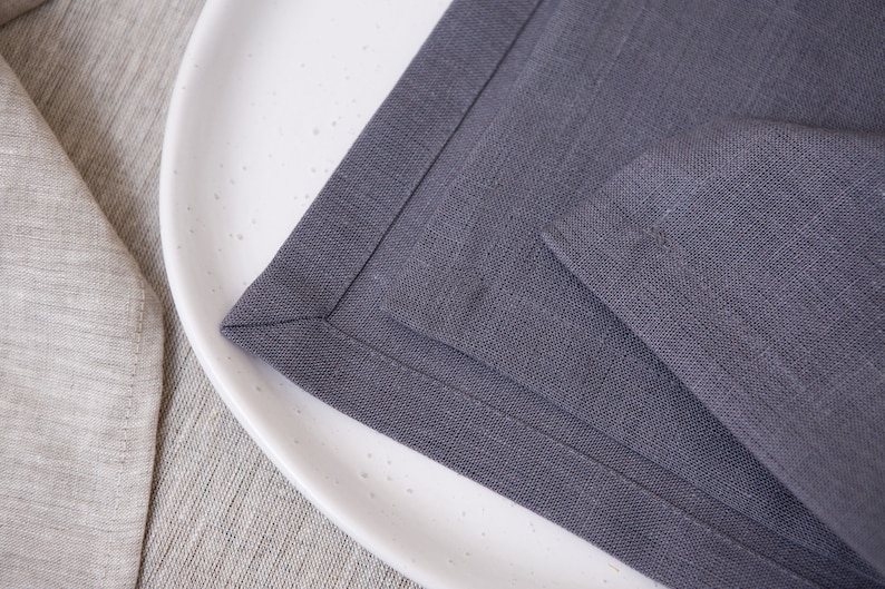 Grey organic linen napkins with elegant mitered corners. Soft washed linen fabric with a refined natural texture, designed for modern table settings, minimalist interiors, farmhouse dining and timeless sustainable home decor. Mitered corners create a clean luxury finish with perfectly folded edges, giving the napkins a more sophisticated and high quality look. Reusable eco friendly dinner napkins handmade for weddings, holiday entertaining, everyday dining, rustic tablescapes and elegant hosting