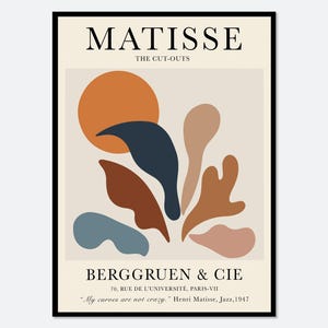 May include: A framed art print featuring the text MATISSE THE CUT-OUTS at the top and BERGGRUEN & CIE at the bottom. The centre displays abstract organic shapes in orange, dark blue, brown, and beige against a light cream background.