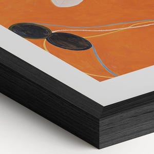 The image is a close-up of a black wood frame surrounding an abstract painting with orange and black colors.