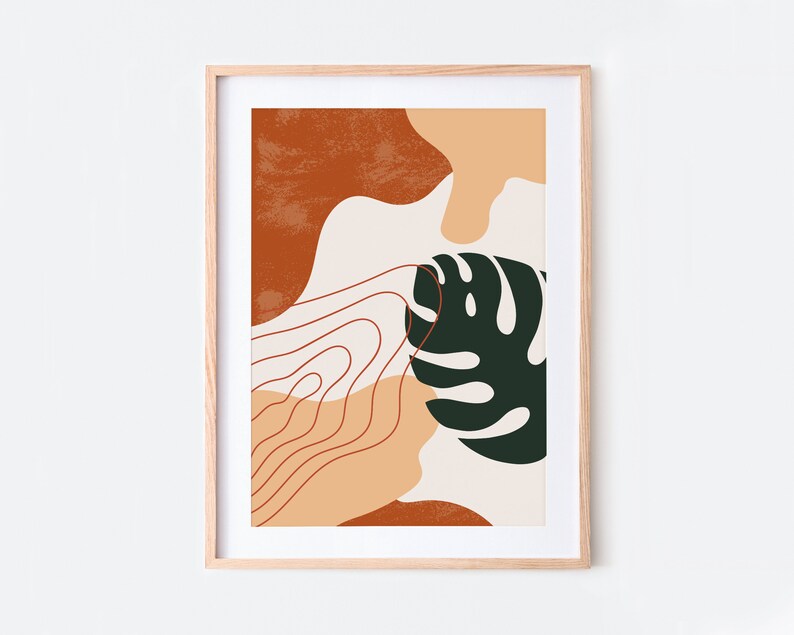 May include: Abstract art print with a green leaf, orange, peach, and white shapes. The print is framed in a light wood frame.