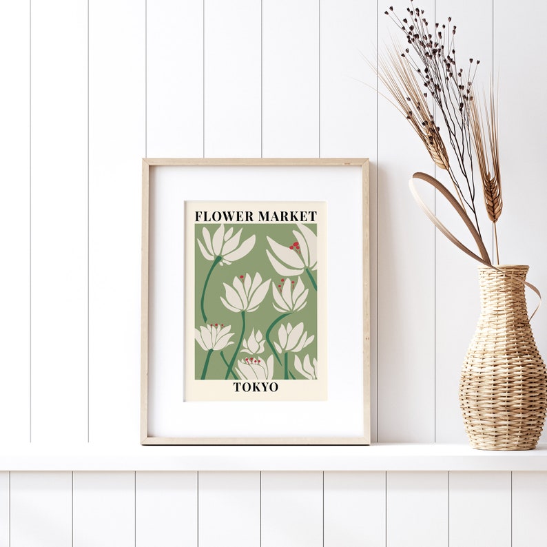 Puede incluir: Una impresi&oacute;n enmarcada con un fondo verde y flores estilizadas blancas. El texto "FLOWER MARKET TOKYO" est&aacute; impreso en la impresi&oacute;n.