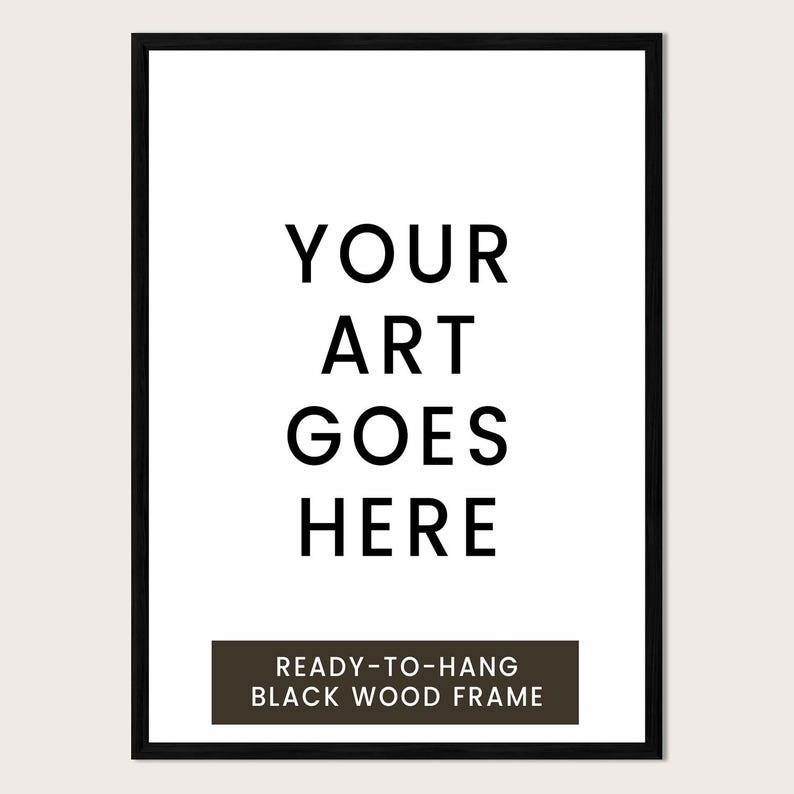 a black and white text-based design with the phrase "YOUR ART GOES HERE" prominently displayed. Below the main text, there is a smaller text that reads "READY-TO-HANG BLACK WOOD FRAME".
