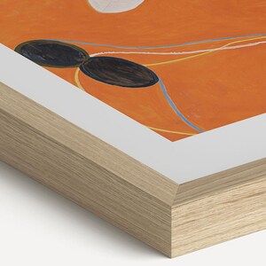 a wooden frame with a vibrant orange background and abstract shapes.