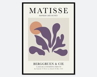 Op de afbeelding: Een ingelijste kunstdruk met de tekst MATISSE PAPIERS DÉCOUPÉS bovenaan en BERGGRUEN & CIE onderaan. De centrale afbeelding toont een effen perzikkleurige cirkel en abstracte paarse organische vormen op een lichtbeige achtergrond.