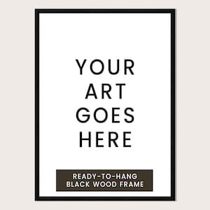a black and white text-based design with the phrase "YOUR ART GOES HERE" prominently displayed. Below the main text, there is a smaller text that reads "READY-TO-HANG BLACK WOOD FRAME".
