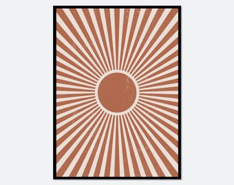 May include: A rectangular wall art print featuring a central terracotta-colored circle surrounded by radiating white and terracotta-colored sunburst lines. The design has a distressed, textured appearance and is enclosed in a thin black frame.