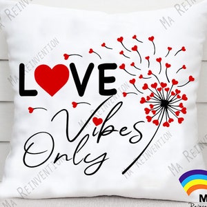 May include: White square cushion featuring the text "LOVE Vibes Only" in black script and a red heart. A dandelion design with red heart-shaped seeds is on the right. A decorative cushion for the home.